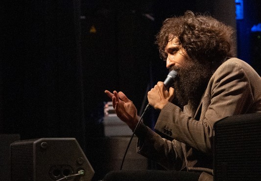 El músico sentado en el alero del escenario